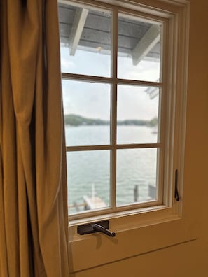 A window with a view of a body of water and a dock.