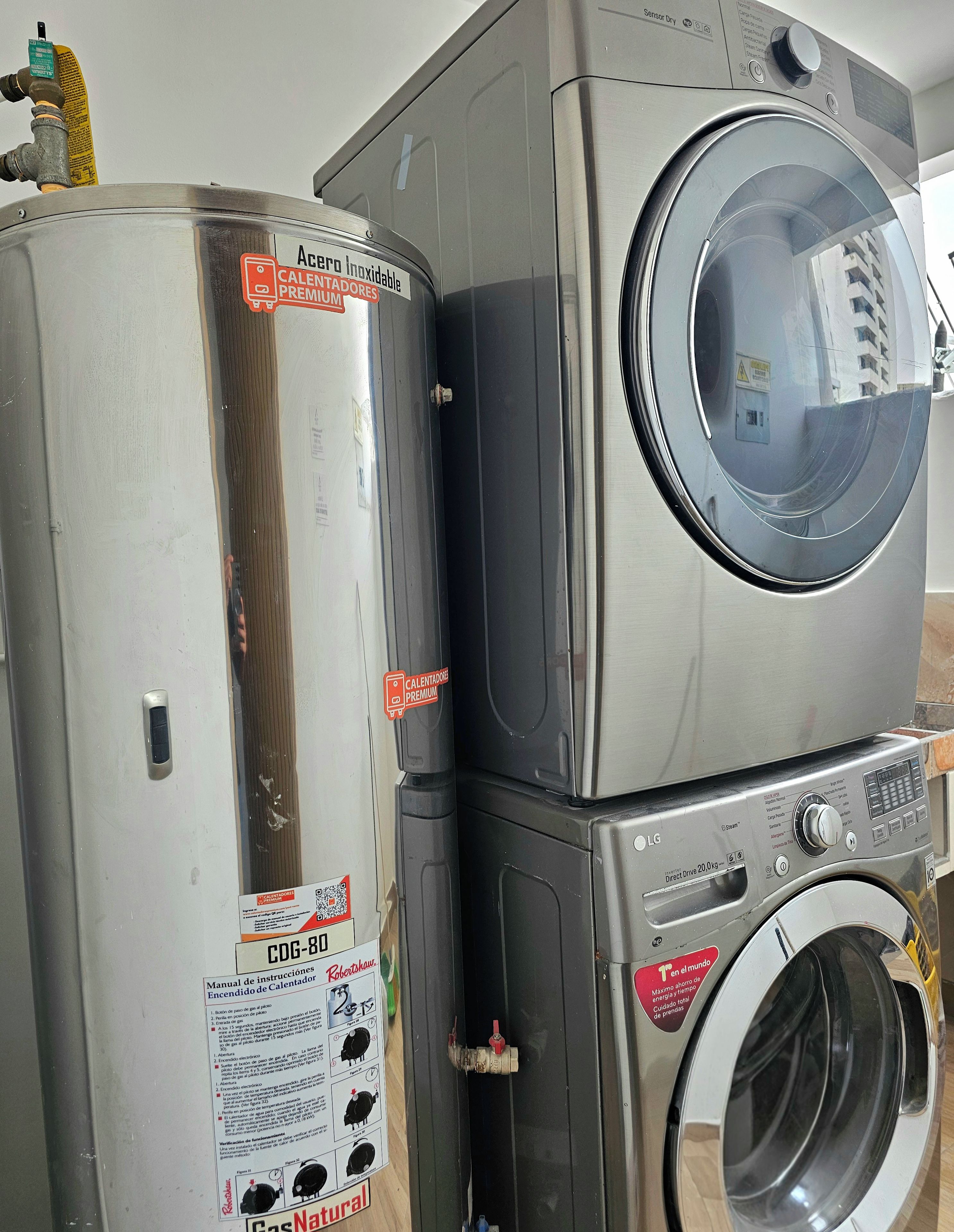 A stacked washer and dryer unit with a manual and a warning label.