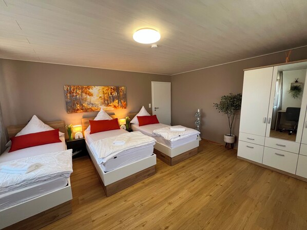 A hotel room with two beds, a wardrobe, a mirror, and a painting on the wall. - Vacation Rental Near Rothenburg / Romantic Franconia (Colmberg)