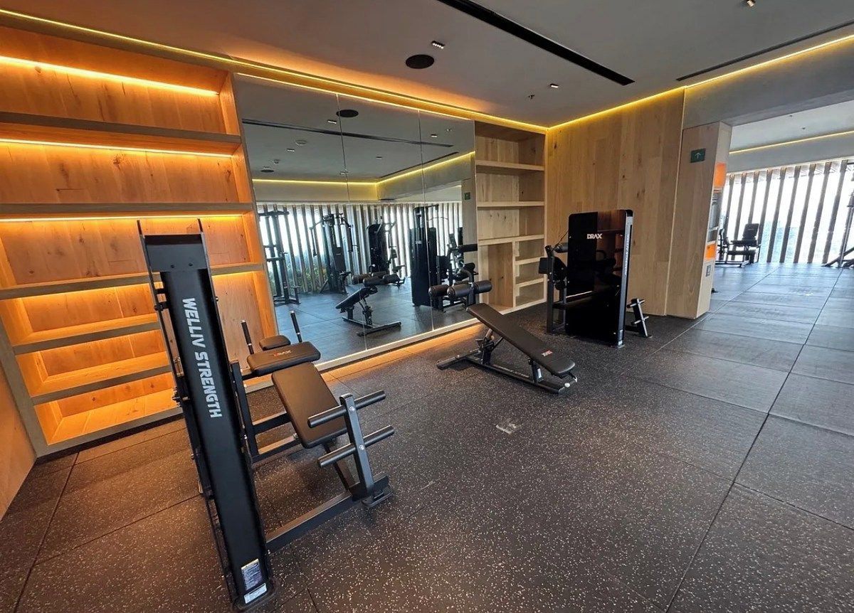 A gym with exercise equipment, a mirror, and wooden paneling.