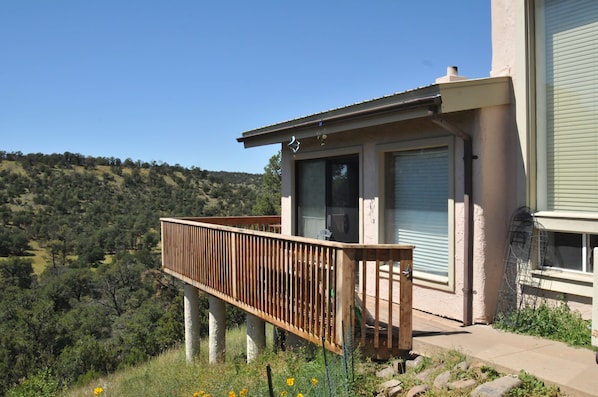 A house with a balcony overlooking a hilly landscape.