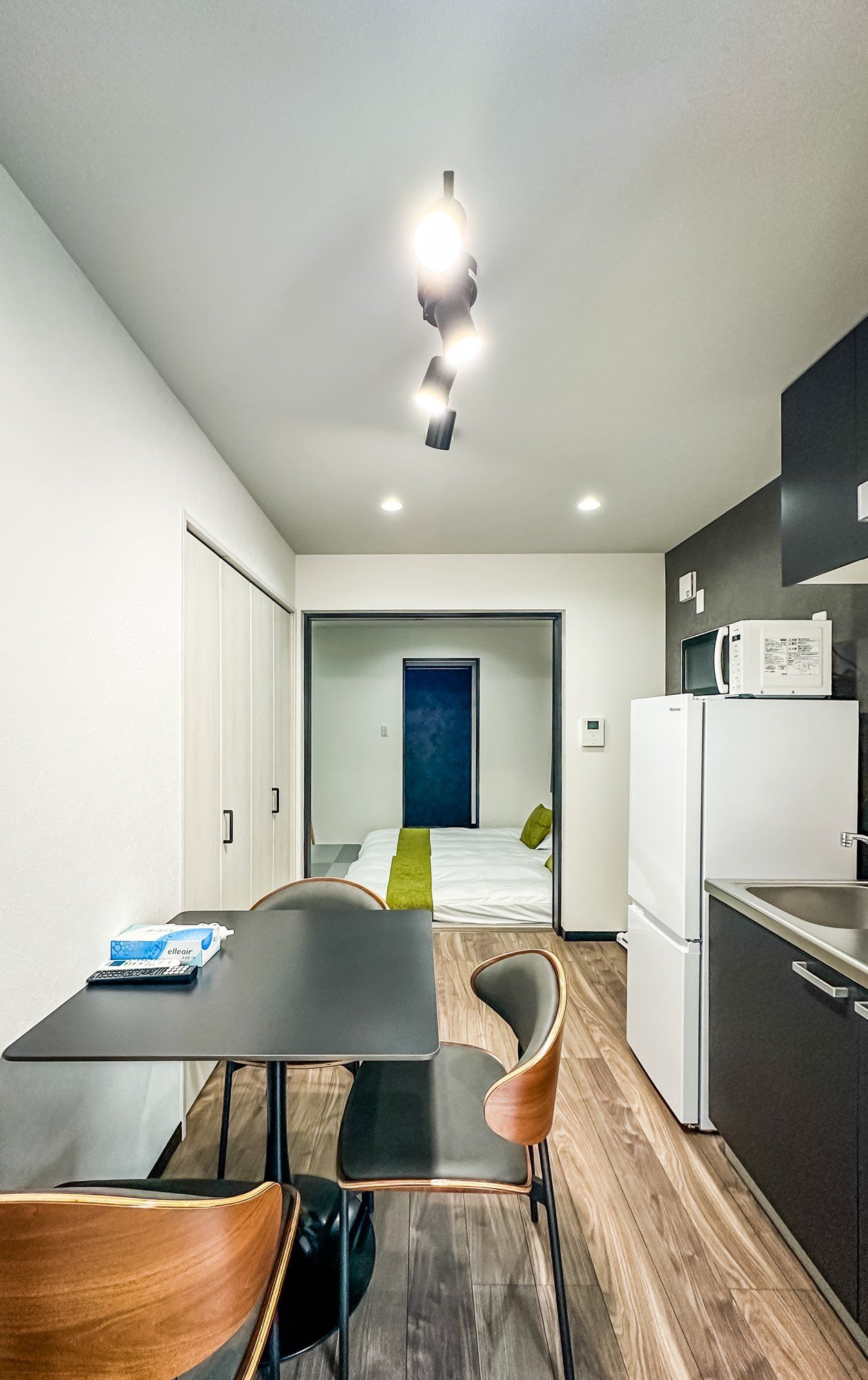 A modern kitchen with a dining area, a microwave, and a refrigerator.