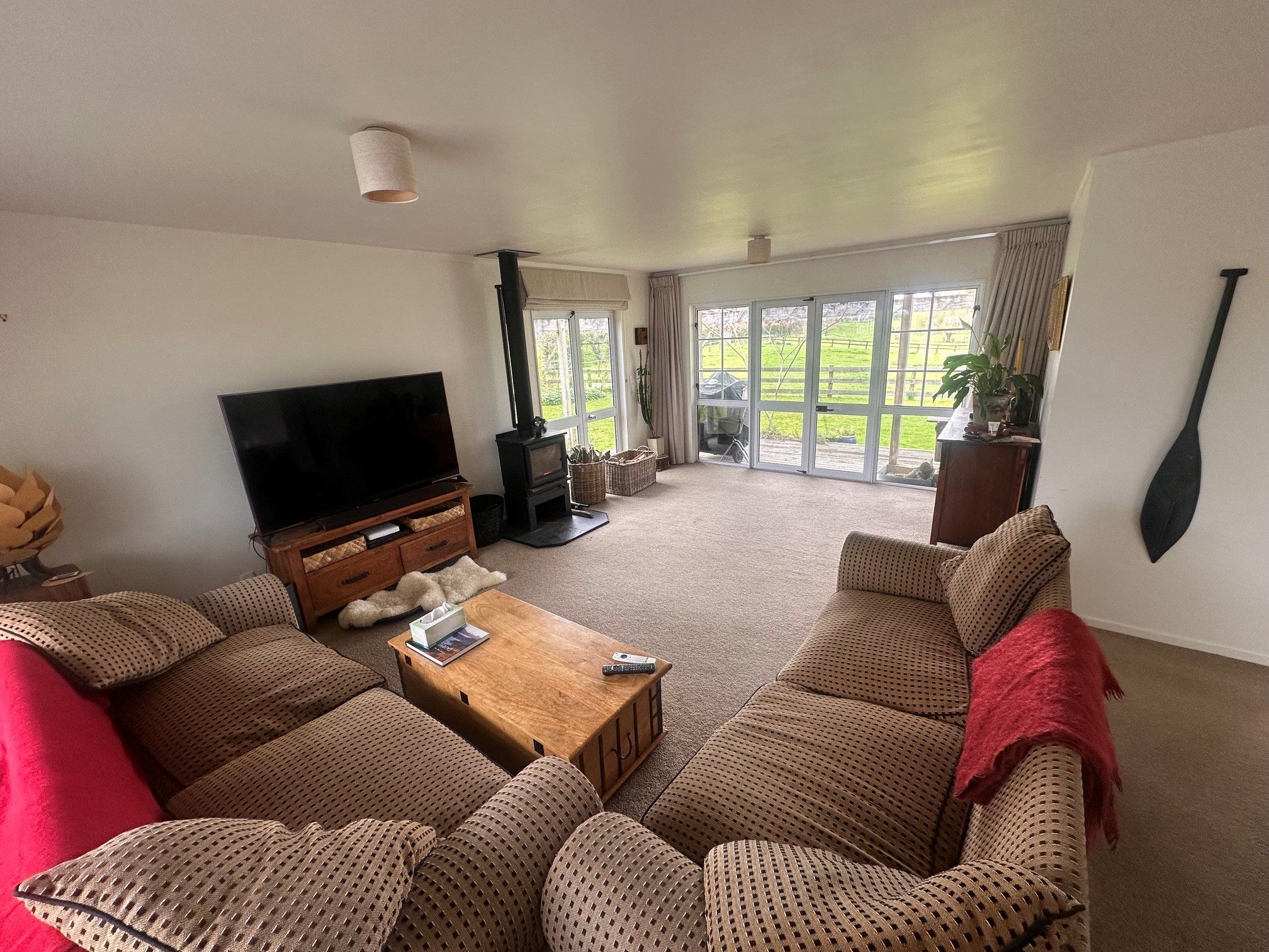 A living room with a television, sofa, coffee table, and a fireplace.