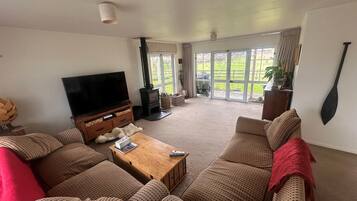 A living room with a television, sofa, coffee table, and a fireplace.