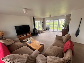 A living room with a television, sofa, coffee table, and a fireplace.
