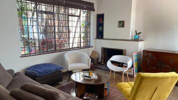 Una sala de estar con sofá, sillones, una mesa de centro y una chimenea.