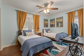 A hotel room with two beds, a ceiling fan, a flat-screen TV, and artwork on the walls. - Retro 2BR · King Bed · Pet-Friendly · TU & Expo (Tulsa)