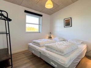 A room with a bunk bed, a window with a view, a hanging light fixture, and a framed picture on the wall. - 8 Person Holiday Home in Hirtshals (Hirtshals)