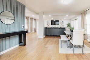 A modern kitchen with a central island, a dining area with a bench, and a large mirror on the wall. - Spacious Meridian Hills Retreat | Quiet & Private (Meridian Hills)