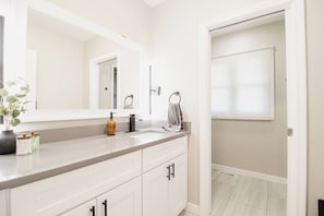 A modern bathroom with a white vanity, a large mirror, and a towel rack. - Spacious Meridian Hills Retreat | Quiet & Private (Meridian Hills)