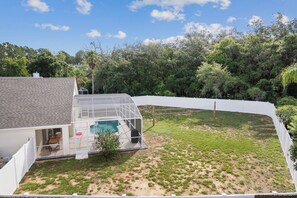 A house with a swimming pool, a covered patio, and a fenced backyard. - Spacious 4-bedroom house in lovely Davenport with AC (Davenport)