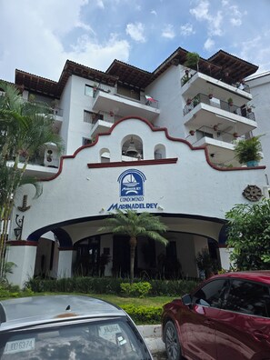 A multi-story building with balconies, a sign indicating it is a Marindel Rey condominium, and a bell above the entrance. - 🛥Marina Vallarta 3BR | Yacht Harbor | Pool & Near the Beach (Puerto Vallarta)