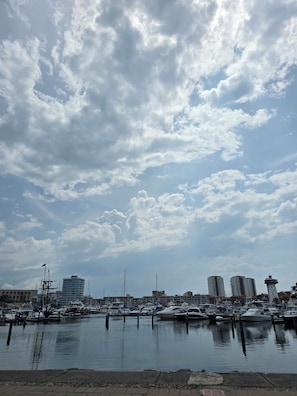 Ein Yachthafen mit vertäuten Booten, ein klarer Himmel und Gebäude im Hintergrund.