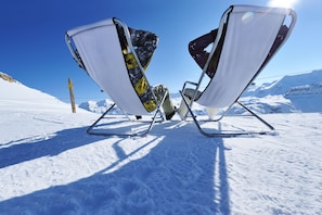 Two white folding chairs on a snowy mountain with a clear blue sky. - Villa Linda Bilo 1-4 Pax (Bardonecchia)