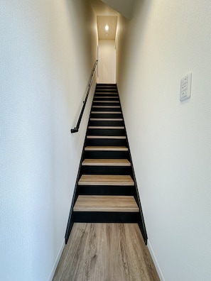 Eine Treppe mit Handlauf und einer Lampe am oberen Ende.
