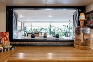 A room with a large window, a bottle of liquor, and a framed picture on the wall. - Polanco Connected | South, North & Mexico City (Mexico City)