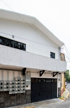 A building with a flat roof, a black gate, and a row of electrical meters. - Modern Loft · 10 Min from Coyoacán Center (Mexico City)