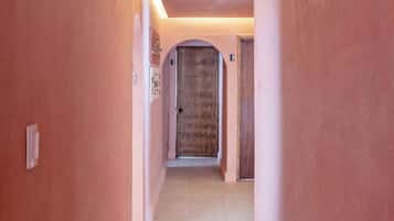 A corridor with a tiled floor and a door at the end.
