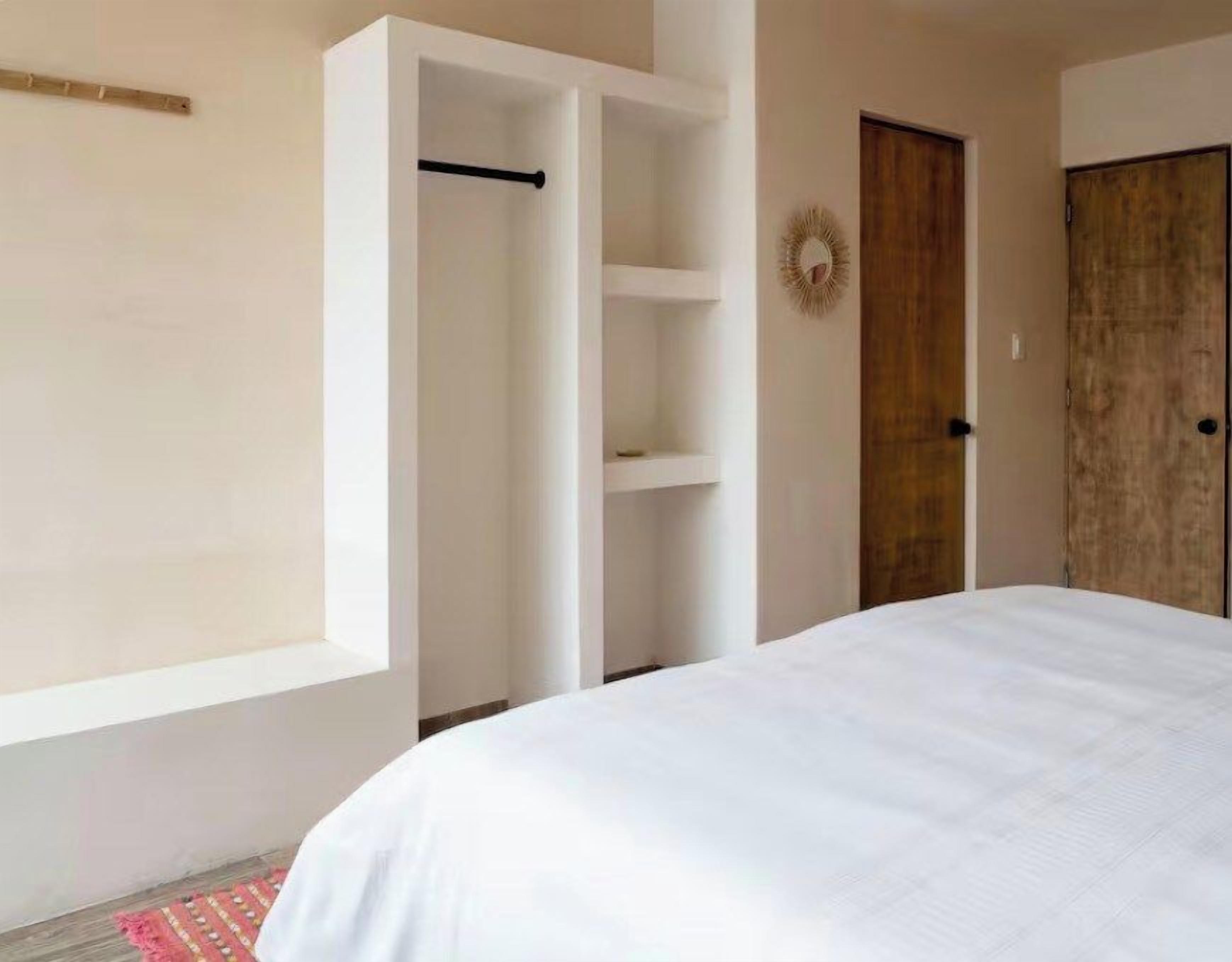 A bedroom with a bed, a wardrobe, and a door.