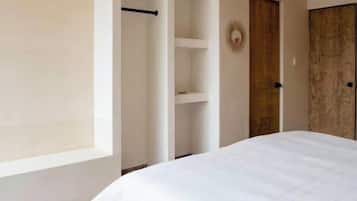 A bedroom with a bed, a wardrobe, and a door.
