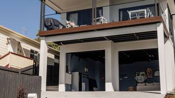 Ein modernes, zweigeschossiges Haus mit überdachter Auffahrt, Garage und kleinem Garten.