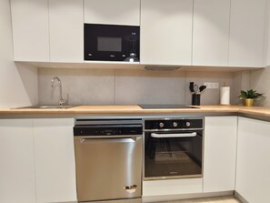 A compact kitchen with a microwave, dishwasher, and oven. - SAN DIEGO APARTMENT (San Bartolomé de Tirajana)