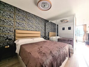 A bedroom with a large bed, a mirror, and a patterned wall. - A SMALL APARTMENT IN MASPALOMAS (Maspalomas)