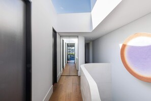 Ein modernes Interieur mit Holzboden, weißen Wänden und einem Oberlicht.