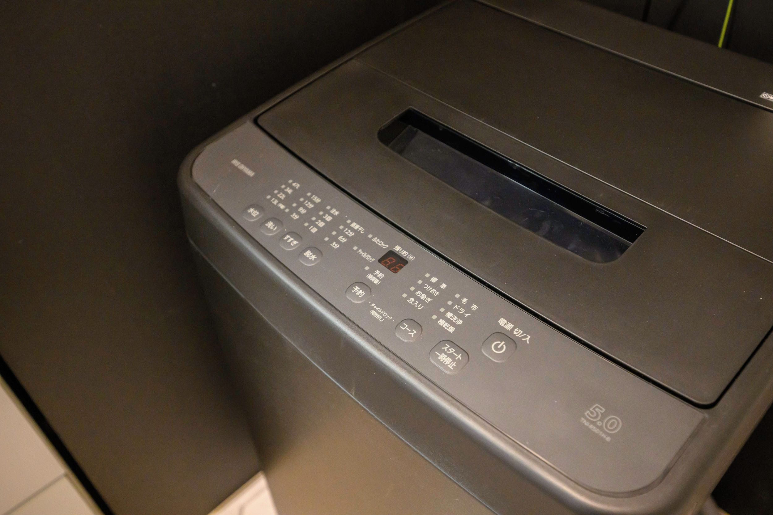 Una impresora negra con un panel de control que incluye varios botones y una pantalla digital.