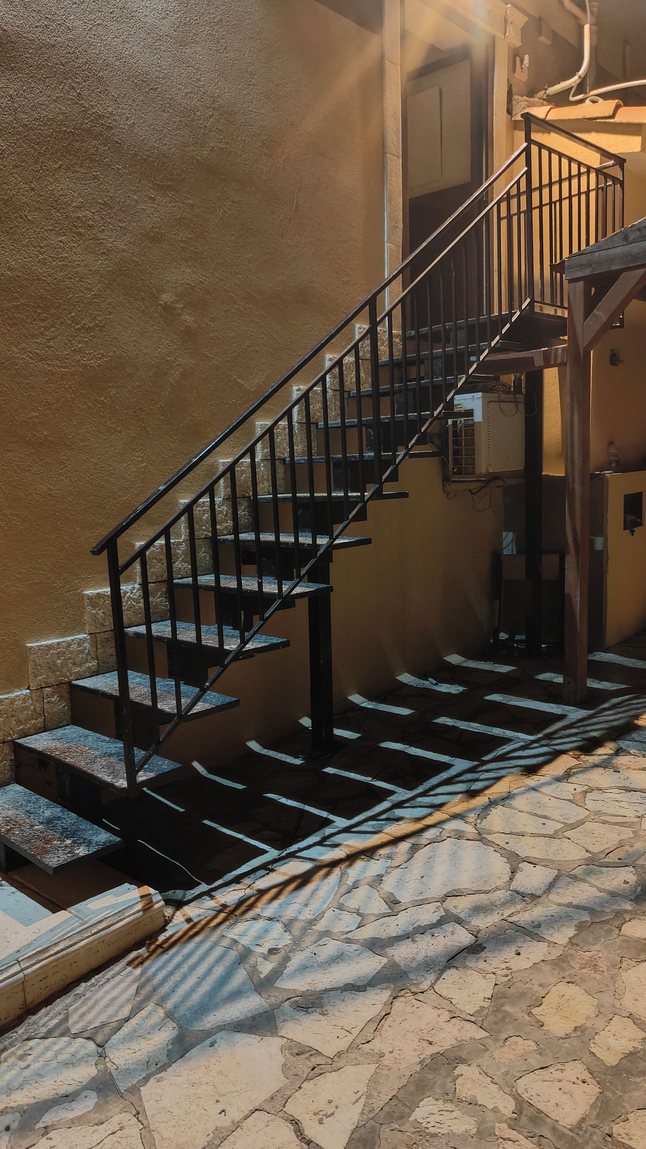 A staircase with black railings leading to a higher level.