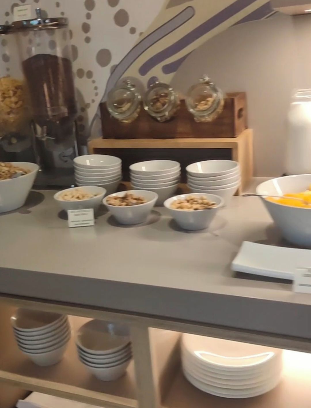 A buffet setup with various food items and bowls of cereal.