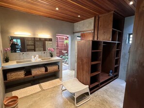 A modern bathroom with a large mirror, dual sinks, wicker baskets, and a wooden vanity. - Villa Colibris – Your Peaceful Haven with Pool (Grand Baie)