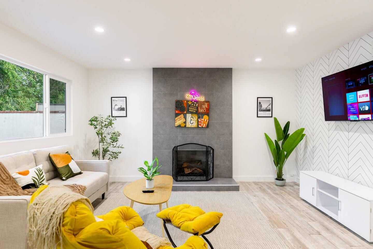 Uma sala de estar moderna com lareira, sofá, mesa de centro e televisão fixada na parede.