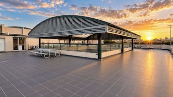 Un edificio moderno con techo curvo y patio cubierto.