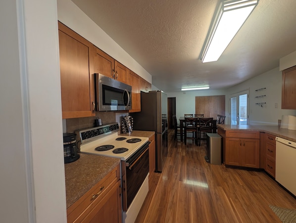 A kitchen with wooden cabinets, a microwave, a stove, and a refrigerator.