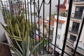 A balcony with a view of a cityscape, featuring buildings with red roofs and balconies. - The Windie Home - Duong Thanh - Hoan Kiem Lake (phuong Hoan Kiem)
