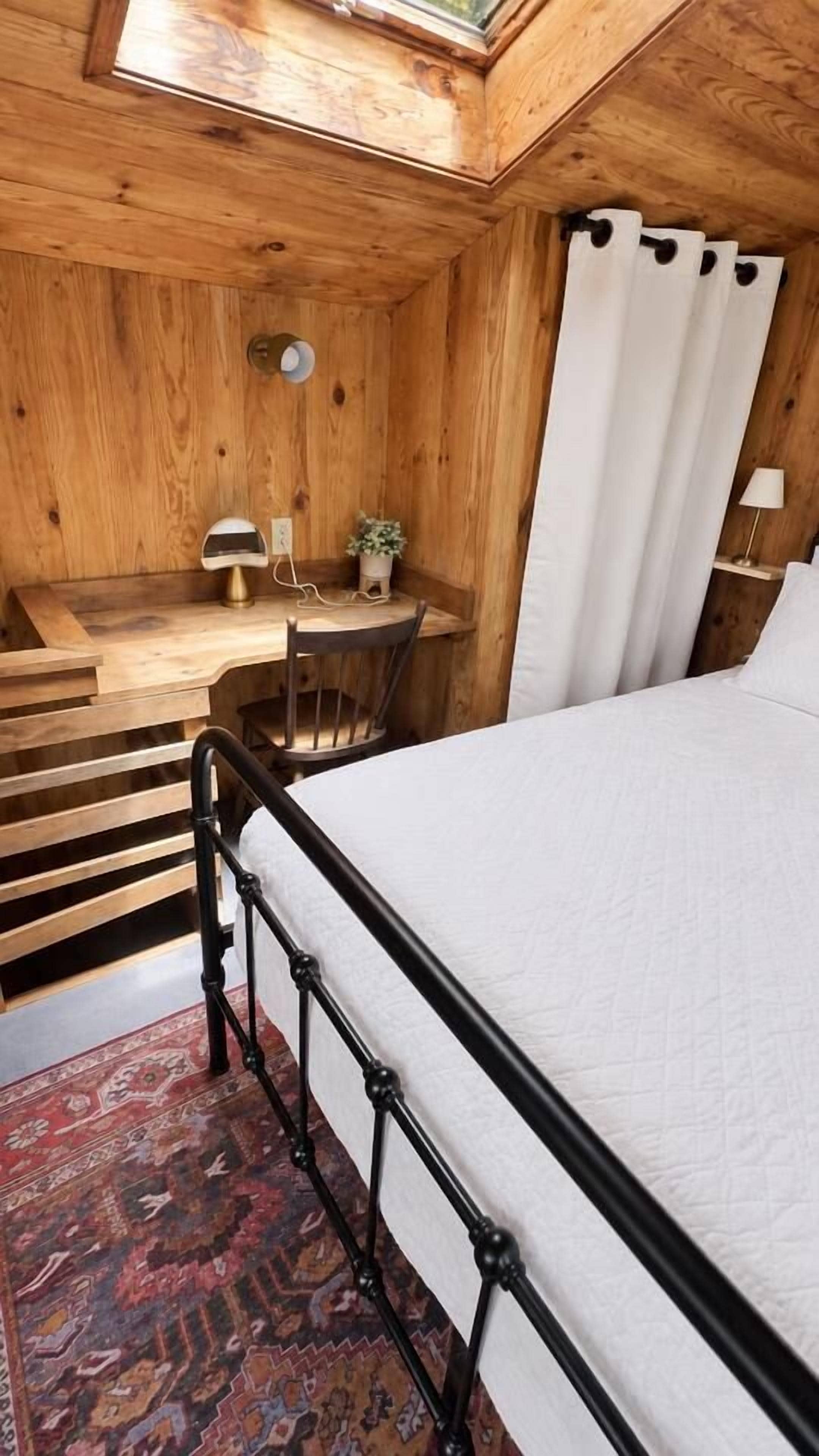 Un intérieur en bois comprenant un lit, un bureau et une chaise.