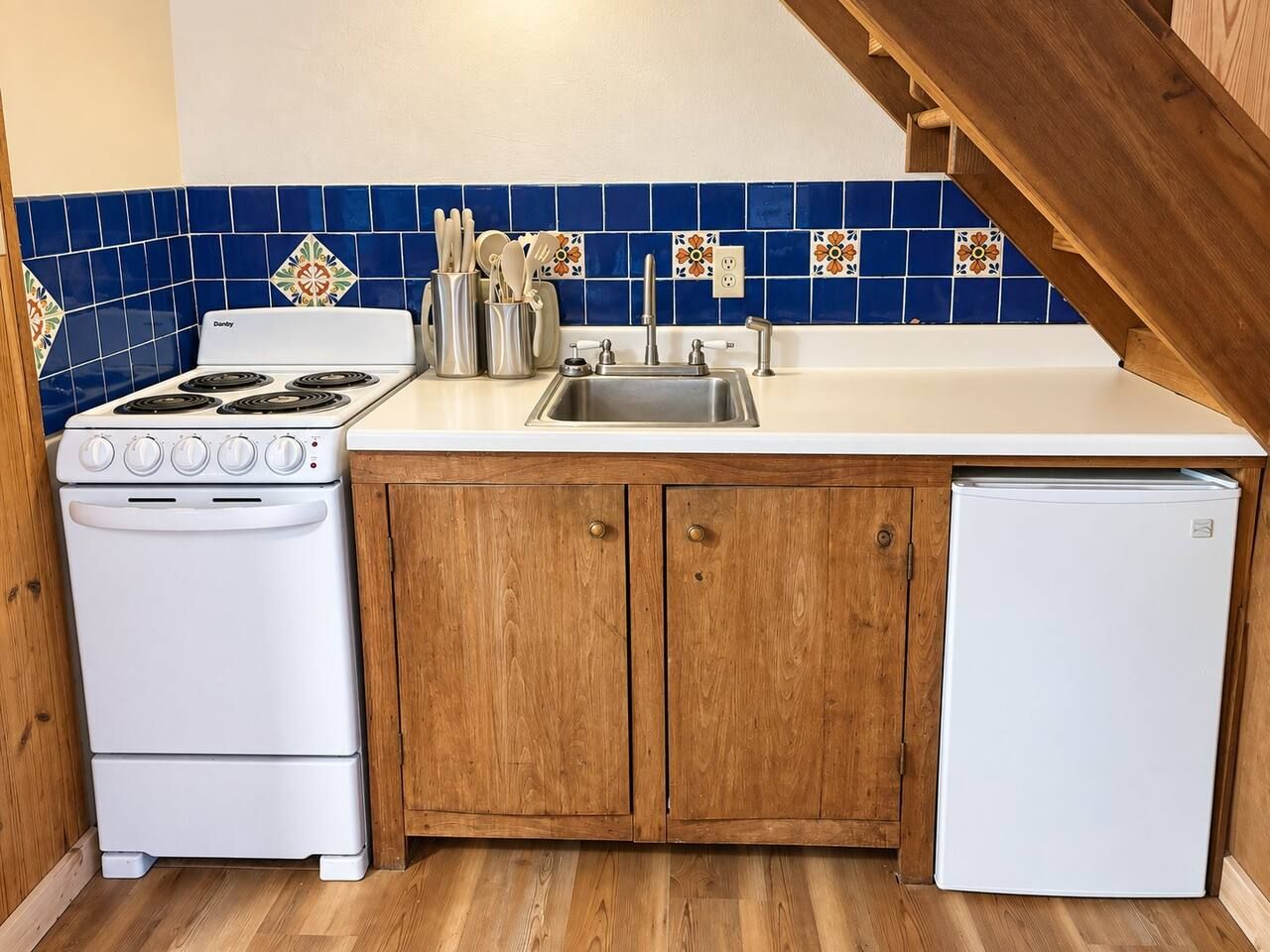 Une cuisine équipée d’une cuisinière, d’un évier et de placards.