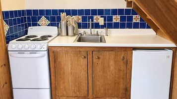 Une cuisine équipée d’une cuisinière, d’un évier et de placards.