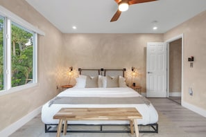 A bedroom with a bed, a ceiling fan, two bedside tables, and a door. - Ft Lauderdale Villa Heated Pool + Arcades, Huge TV + yard (Fort Lauderdale)