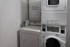 A laundry area with a sign stating 'Motel 6 is not responsible for items left unattended.'