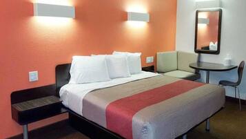 Ein Hotelzimmer mit Bett, Nachttischen, Schreibtisch und Stuhl.