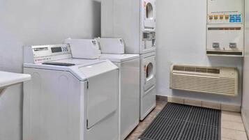 A laundry room with a washing machine, dryer, and a wall-mounted heater.