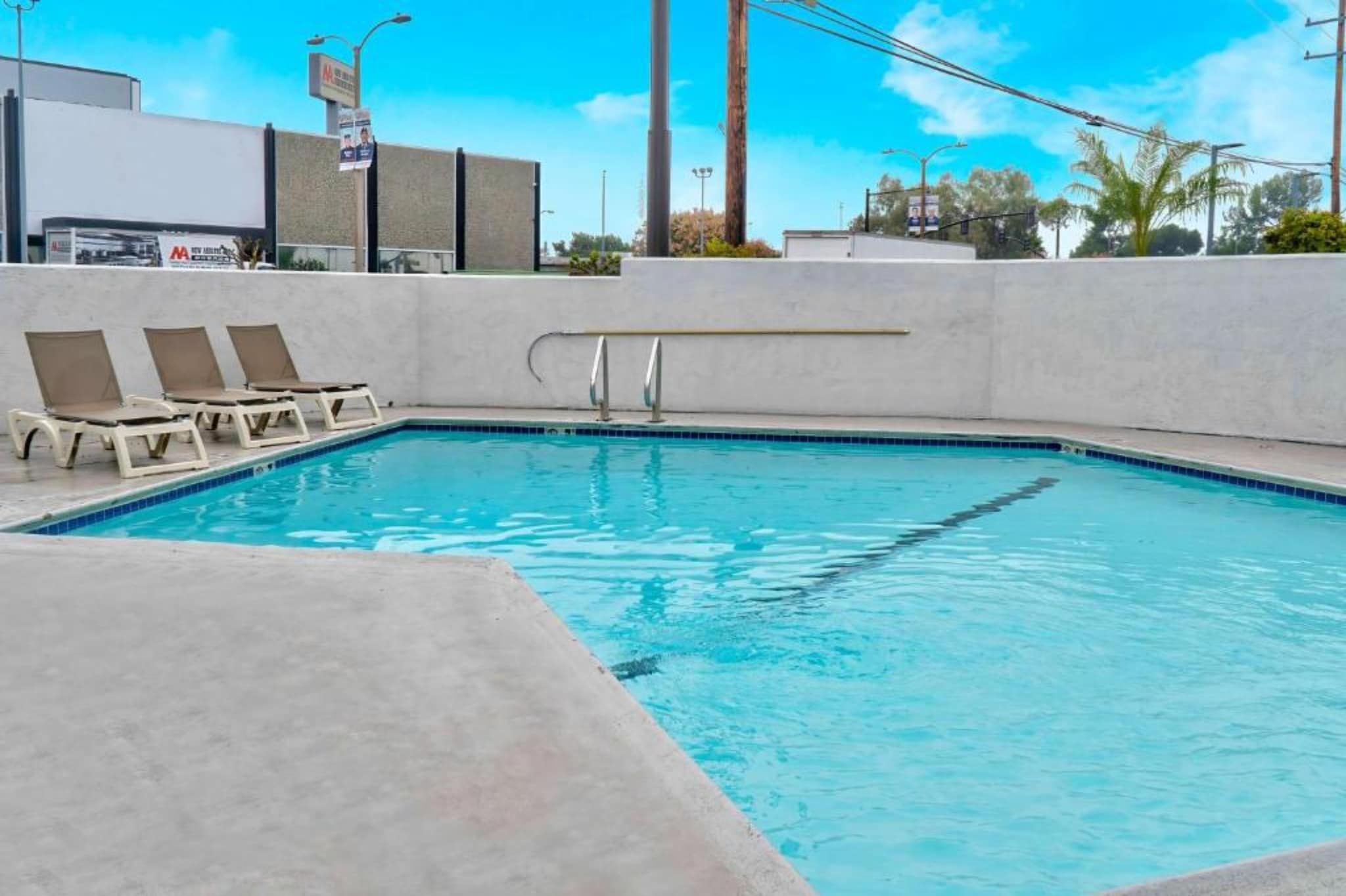 A swimming pool with lounge chairs and a lifeguard stand.