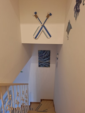 Eine Treppe mit einer weißen Brüstung und einem blau-weiß gestreiften Gegenstand, der von der Decke hängt.
