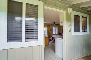 A hallway with a door leading to a bedroom, a ceiling fan, and a 'No Smoking' sign. - Walk to Shore! Waimanalo Beach Cottages, Unit 9 (Waimanalo)