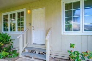 A house with a front porch, a white door, and a window with a view of the outdoors. - Walk to Ocean! Waimanalo Beach Cottages: Unit 5 (Waimanalo)