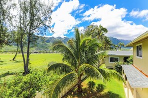 A residential property with a well-maintained lawn, a palm tree, and a house with a sloped roof. - Extended Escape! Waimanalo Beach Cottages, Unit 11 (Waimanalo)