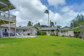 A residential area with multiple houses, a grassy yard, and a clear sky. - Waimanalo Beach Cottages - Large Studio, Unit 4 (Waimanalo)