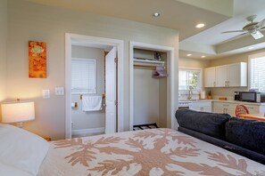 A hotel room with a bed, a sofa, a kitchenette, and a bathroom. - Waimanalo Beach Cottages - Large Studio, Unit 4 (Waimanalo)